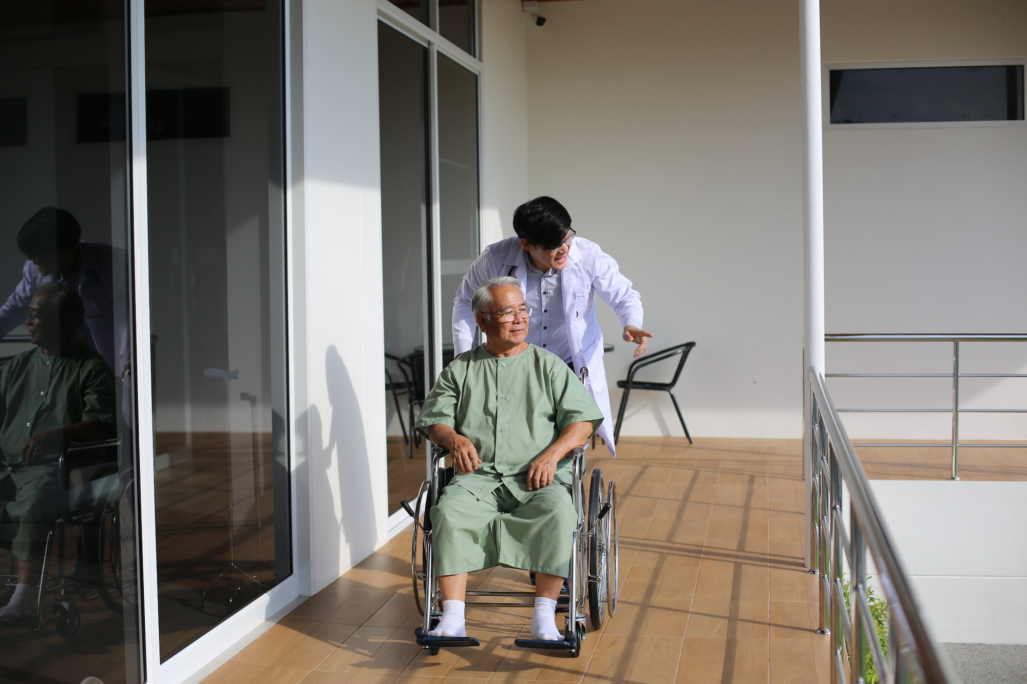caretaker-helping-senior-man-with-disability-at-checkup-visit.jpg
